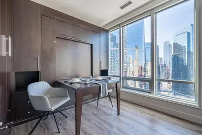 a room with a desk with a chair and large windows at Gorgeous City Views Central Studio Walk to Seawall in Vancouver