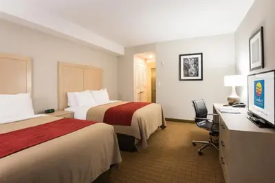 a hotel room with two beds and a desk with a computer at Comfort Inn & Suites in Campbell River