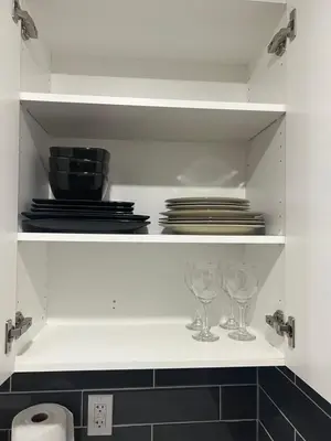 a white shelf with plates and glasses on it at Beautiful suite in Balzac