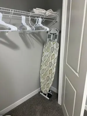 a tie hanging on a shelf in a closet at Beautiful suite in Balzac