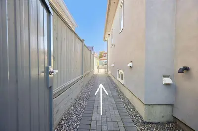 an alley between two buildings with a white arrow at Basement Suite In Vancouver in Vancouver