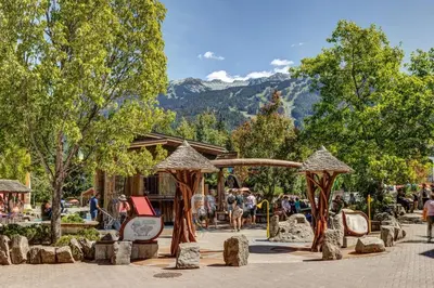 a group of people walking around a park at Whistler Village 2BR 2BA Top-Floor Condo with Hot Tub and Parking in Whistler