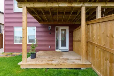 a house with a wooden porch with a fence at Exquisite One Bedroom Apartment in NW in Calgary