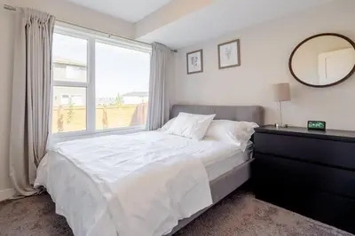 a bedroom with a large bed and a window at Exquisite One Bedroom Apartment in NW in Calgary