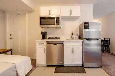 a kitchen with a stainless steel refrigerator and a microwave at Exquisite One Bedroom Apartment in NW in Calgary