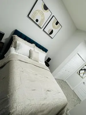 a bedroom with a large bed with a blue headboard at The Glacier Royale - 1 Bed Suite in NW Calgary in Calgary