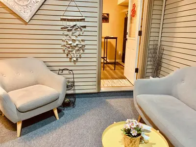 a porch with two chairs and a table and a chandelier at Scorpio House Langley - Semi-basement Suite in Langley