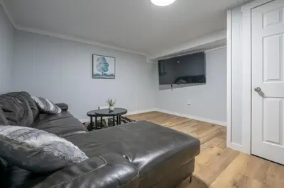 a living room with a leather couch and a table at Cute HighlandPark House in Calgary