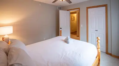 a bedroom with a white bed and a lamp at Stone Creek Chalet by Fernie Lodging Company in Fernie
