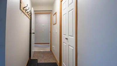 a hallway with white doors and a stairway with a mirror at Stone Creek Chalet by Fernie Lodging Company in Fernie