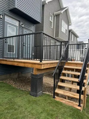 a deck with black railings on a house at Chic & Cozy 2-BR Suite at Glacier Ridge NW Calgary in Calgary