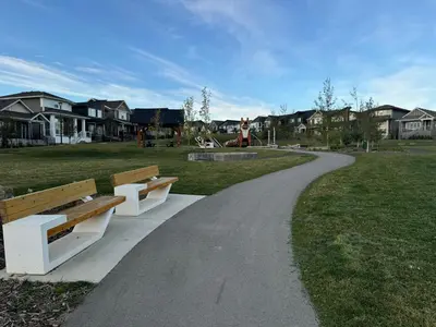 two benches sitting on a path in a park at Chic & Cozy 2-BR Suite at Glacier Ridge NW Calgary in Calgary