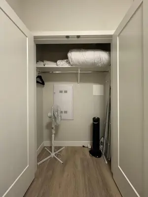 a room with a closet with a bed and a fan at Stylish Modern Apartment In The Heart Of Old Town Victoria in Victoria