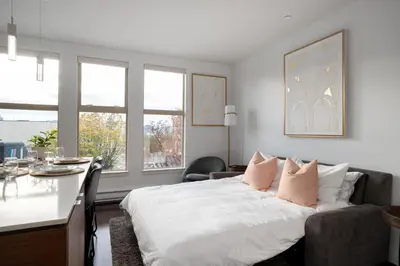 a bedroom with a bed with pink pillows at Chic And Cozy Apartment In Old Town in Victoria