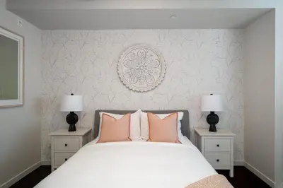 a bedroom with a white bed with pink pillows at Chic And Cozy Apartment In Old Town in Victoria