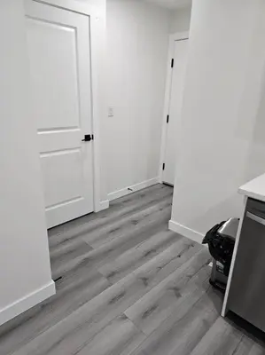 an empty room with white walls and wooden floors at Comfort Guest Suite NE Calgary - Near Airport in Calgary