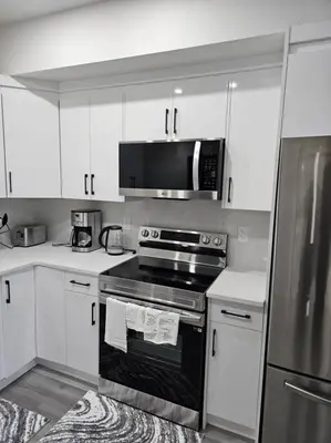 a kitchen with a stove and a microwave at Comfort Guest Suite NE Calgary - Near Airport in Calgary