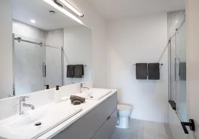a white bathroom with two sinks and a toilet at Mountain Revelation by Revelstoke Vacations in Revelstoke