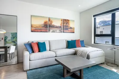 a living room with a white couch with colorful pillows at Mountain Revelation by Revelstoke Vacations in Revelstoke