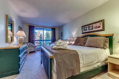 a bedroom with a bed and a desk and a chair at Greystone Lodge 214 Ski-in Out in Whistler