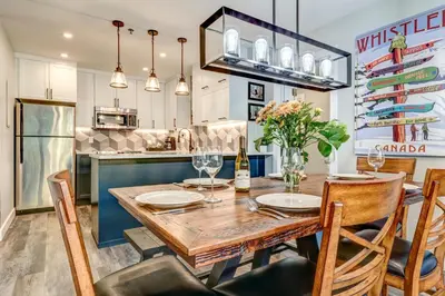 a kitchen and dining room with a wooden table and chairs at Greystone Lodge 329 Ski-in Out in Whistler