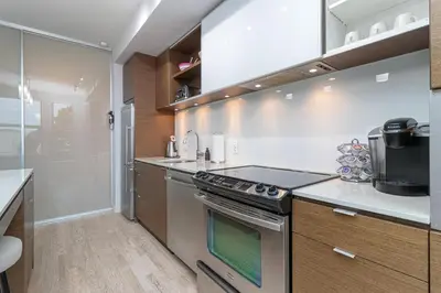 a kitchen with a stove top oven next to a counter at Chic And Cozy Condo In Old Town Victoria in Victoria