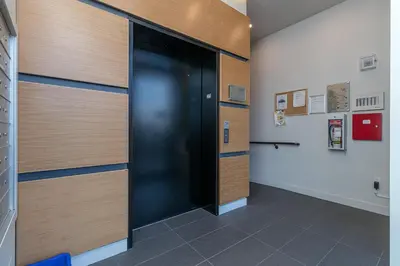 a hallway with a black door in a building at Chic And Cozy Condo In Old Town Victoria in Victoria