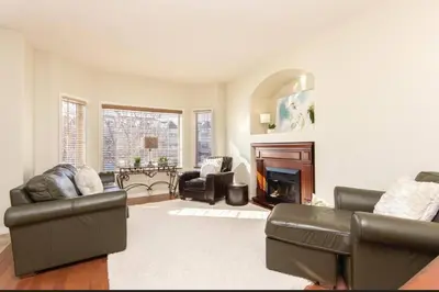 a living room with leather furniture and a fireplace at Spacious 3bedrm for family or business travellers in Red Deer