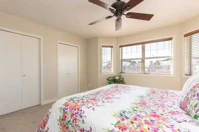 a bedroom with a bed and a ceiling fan at Spacious 3bedrm for family or business travellers in Red Deer