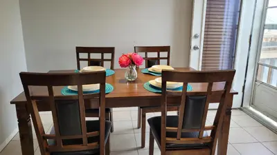a dining room table with chairs and a vase of flowers at Elegant 4-Bedroom Family Home Master in Calgary