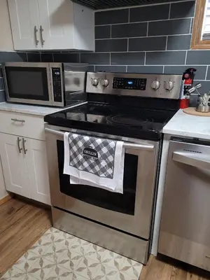 a kitchen with a stainless steel stove and a microwave at Elegant 4-Bedroom Family Home Master in Calgary