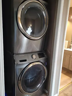 a washing machine and a dryer in a room at Elegant 4-Bedroom Family Home Master in Calgary