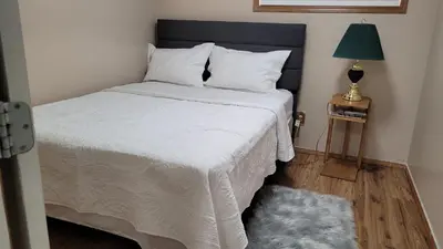 a bedroom with a large white bed with a lamp at Elegant 4-Bedroom Family Home Master in Calgary