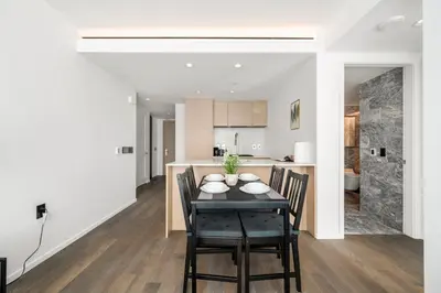 a dining room and kitchen with a table and chairs at Luxury High-Rise Condo with Stunning Views in Vancouver