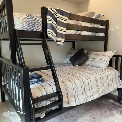 a black cat laying on a bed next to a bunk bed at Cozy Cove Retreat Escape to Tranquility Stay in Simplicity in Dead Man's Flats