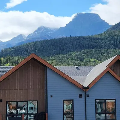 a building with mountains in the background at Cozy Cove Retreat Escape to Tranquility Stay in Simplicity in Dead Man's Flats