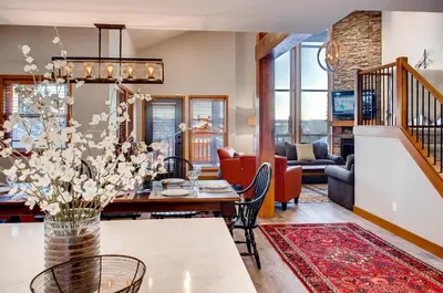 a dining room and living room with a table and chairs at Moonshine Crescent 385 by Okanagan Premier in Big White