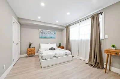 a white bedroom with a bed and a window at Modern Studio Unit - Close to DT in Edmonton