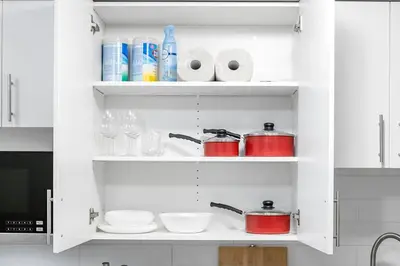 a kitchen cabinet filled with dishes and cups and a microwave at Modern Studio Unit - Close to DT in Edmonton