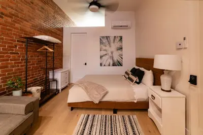 a bedroom with a bed and a brick wall at Stylish downtown apartment in Grand Forks, BC in Grand Forks
