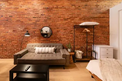 a living room with a couch and a brick wall at Stylish downtown apartment in Grand Forks, BC in Grand Forks