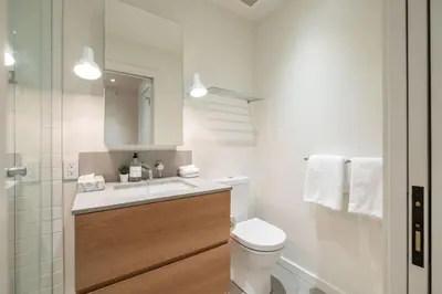 a bathroom with a toilet and a sink and a mirror at Blueberry Hill Estates 3144 by Outpost Whistler in Whistler