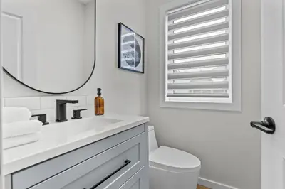 a white bathroom with a sink and a mirror at ML4- Private Rooftop Hot Tub Oasis- Entire townhouse with MTN View in Canmore