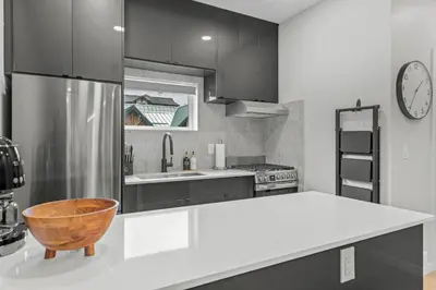 a kitchen with black cabinets and a wooden bowl at ML4- Private Rooftop Hot Tub Oasis- Entire townhouse with MTN View in Canmore