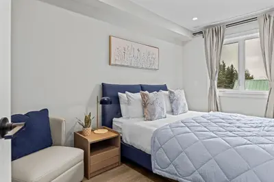 a bedroom with a blue bed and a chair at ML4- Private Rooftop Hot Tub Oasis- Entire townhouse with MTN View in Canmore