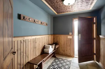 a hallway with a bench in a room with a door at Dwight Out Chalet with Hot Tub in Big White