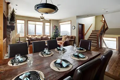 a dining room with a large wooden table and chairs at Dwight Out Chalet with Hot Tub in Big White