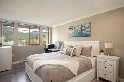 a bedroom with a bed and a desk with a computer at 2BR in Nicklaus North Clubhouse, Lake and Mountain Views, Gas Fireplace, Parking in Whistler