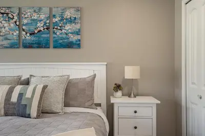 a bedroom with a bed and a table with a lamp at 2BR in Nicklaus North Clubhouse, Lake and Mountain Views, Gas Fireplace, Parking in Whistler