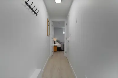 a hallway with white walls and a white room at Modern Suite by Royal Alexandra Hospital l Free Parking WiFi Netflix in Edmonton